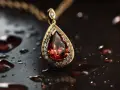 Złoty wisiorek z łzą rubinu i diamentami, niczym symbol panny znak zodiaku, lśni wśród kropli wody.