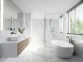Salle de bain moderne avec baignoire îlot, double vasque et douche vitrée. La faïence marbrée blanche illumine l'espace, créant une ambiance épurée et luxueuse.