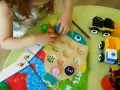 Dziecko bawi się drewnianą rybką z kółkami i cyferkami, ćwicząc metodę Marty Bogdanowicz Dobrego Startu.