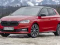 Czerwona Skoda Fabia Monte Carlo z czarnym dachem na tle ośnieżonych gór.