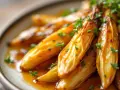 Endives caramélisées à la poêle, nappées d'une sauce dorée et parsemées de persil frais. Un délice fondant.