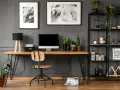Arredamento studio casa: scrivania in legno con computer, sedia, piante e libreria nera piena di oggetti decorativi.