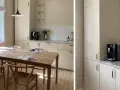 Ljust kök med träbord och stolar. Nya köksluckor ger ett fräscht intryck. Kaffemaskin och blommor på bänken.