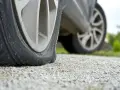 Płaska opona w samochodzie, nawet z technologią runflat, leży na żwirze.