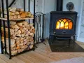 En kamin med glödande eld och en vedstapel redo för att installera kamin.