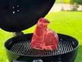 Una succulenta bistecca fiorentina cruda riposa sulla griglia di un barbecue, pronta per essere cucinata all'aperto.