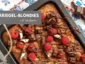 Kinderriegel-Blondies mit Himbeeren: Ein saftiger Kuchen, dekoriert mit Schokolade und frischen Beeren. Perfekt für das Blondies Rezept!