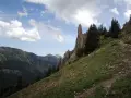 Ein steiler Bergpfad führt am markanten Siplinger Kopf vorbei, umgeben von grünen Hängen und Nadelbäumen.