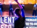 Silent Disco Berlin im Tiergarten. Leute tanzen mit leuchtenden Kopfhörern im Dunkeln.