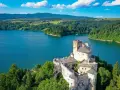 Zamek w Niedzicy góruje nad turkusowym zalewem czorsztyńskim, otoczony zielonymi lasami i górami.