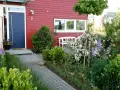 Reihenhaus mit kleinem Vorgarten: Ideen für blühende Beete, ein Weg aus Granit und eine weiße Bank laden zum Verweilen ein.