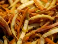 Pokrojone w słupki marchewka, fasolka i inne warzywa w daniu stir-fry.
