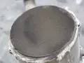 Zbliżenie na zapchany filtr DPF z widoczną siateczką i izolacją.