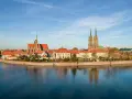 Wrocław stare miasto z katedrami i Ostrów Tumski nad Odrą, odbijające się w spokojnej wodzie.