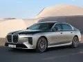 Elegancki BMW 740d w dwukolorowym malowaniu, zaparkowany przed nowoczesnym budynkiem.