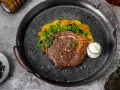 Un jugoso lomo bajo de vaca a la parrilla, acompañado de patatas crujientes y una salsa cremosa. ¡Un festín para los sentidos!