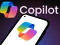 Kolorowe logo Copilot 365 na ekranie smartfona i w tle.