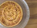 Tarte aux pommes dorée sur un plat en verre, parfaite pour une recette gâteau avec pâte feuilletée facile.