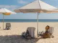 Leżaki i parasole na piaszczystej plaży nad morzem.
