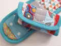 Idée couture : tissu matelassé aux motifs géométriques et floraux, bordé de biais turquoise. Parfait pour un manique ou un dessous de plat original.