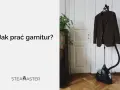 Brązowy garnitur wisi na stojaku obok parownicy. Czy garnitur można prać w pralce? Zobacz, jak odświeżyć ubranie.