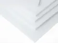 Kilka białych arkuszy tarflenu ułożonych warstwowo, tworzących geometryczny wzór.