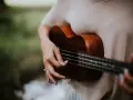 Dłoń grająca na ukulele, które jest często uważane za instrument, na którym najłatwiej nauczyć się grać.
