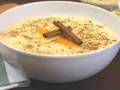 Delicioso arroz con leche thermomix, espolvoreado con canela y decorado con piel de naranja y limón.