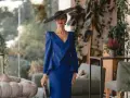 Elegante mujer con vestido azul klein y sombrero, ideal para saber como combinar un vestido azul klein para una boda.
