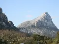Vue hivernale du pic Saint-Loup, ses pentes couvertes de neige contrastant avec le ciel bleu.