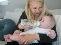 Mama karmi dziecko z butelki antykolkowej Dr Brown's z uroczym motywem lisów.