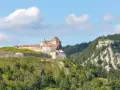 Fort de Joux, un site historique à visiter dans le Doubs, perché sur une colline verdoyante sous un ciel bleu.