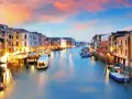 Il Canal Grande di Venezia, con le sue opere d'arte architettoniche illuminate al tramonto, accoglie gondole e vaporetti.