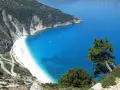 Malownicza plaża Myrtos na Kefalonii, Grecja w październiku. Kręta droga prowadzi do białego piasku i turkusowego morza.