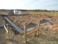 Rozpoczęto wylewanie fundamentu pod nowy dom. Wykopano rowy, w których widać świeży beton.