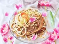 En vacker pannkakstårta med äpple, kanel och valnötter, perfekt för ett pannkakstårta recept. Omgiven av rosa tulpaner.