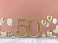 Złote myśli na 50 urodziny: złota liczba 50, balony i prezenty tworzą radosną atmosferę świętowania.