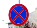 Znak drogowy: zakaz parkowania. Czerwone koło z niebieskim tłem i dwoma czerwonymi skrzyżowanymi pasami.