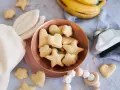 Kleine Sterne und Herzen: Baby Kekse backen ab 6 Monate. Dazu Bananen und ein Holzspielzeug.