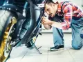 Mechanik sprawdza motocykl. Dowiedz się, ile kosztuje przegląd motocykla, zanim oddasz go do serwisu.