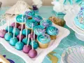 Söta cupcakes och cake pops i lila och turkost, perfekta att köpa till babyshower. Havstema med pärlor och snäckskalsformade tallrikar.