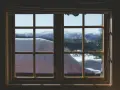Finestra con infissi in legno, vista su paesaggio innevato. Ideale per chi vuole rinnovare infissi in legno fai da te.