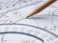 Ołówek kreśli linie na rysunku technicznym, gdzie widać linijkę, kątomierz i znak równoległości.