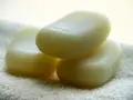 Trzy kostki mydła ze srebrem koloidalnym leżą na białym ręczniku.