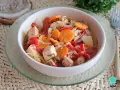 Pechuga de pollo en escabeche con zanahoria, pimiento rojo y cebolla, servida en un cuenco blanco sobre una base tejida.