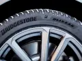 Opony zimowe Bridgestone Blizzak na feldze, pokryte śniegiem. Wiele pozytywnych opony Bridgestone opinie potwierdza ich jakość.
