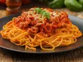 Pyszne spaghetti bolognese z mielonym mięsem, polane sosem pomidorowym i posypane serem. Idealne pytanie: jakie mięso do spaghetti?