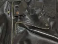 Dettaglio di una giacca in ecopelle nera con zip dorata e bottoni a pressione. Si pensa a come lavare giacca ecopelle in lavatrice.