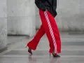 Czerwone spodnie dresowe z białymi lampasami i eleganckie szpilki. Odważne połączenie, które odpowiada na pytanie: jakie buty do dresów?
