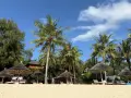 Plaża na Zanzibarze, palmy, leżaki pod strzechą. Wiza na lotnisku Zanzibar już za nami, czas na relaks.